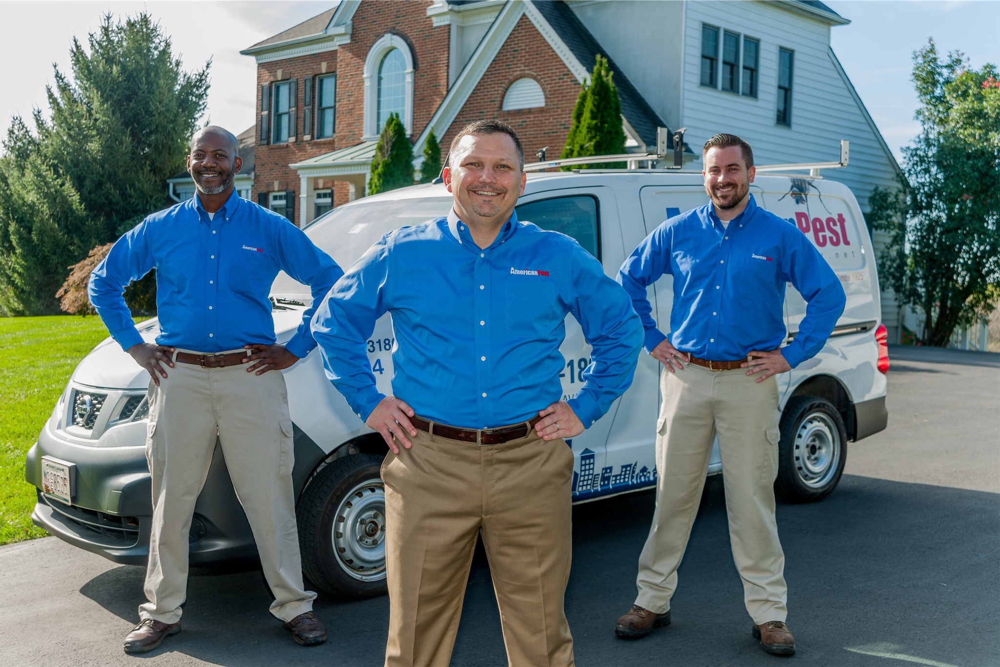 american pest technicians in front of a residential home in maryland