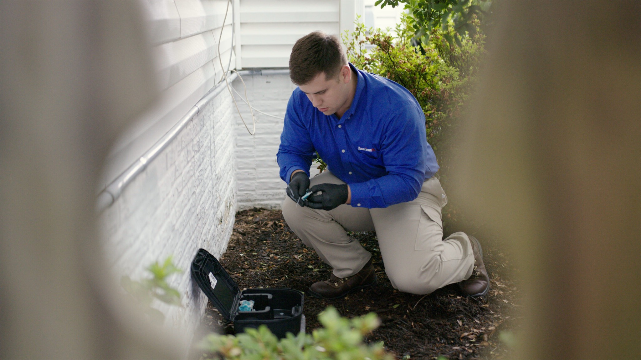 checking and updating rodent control bait station outside of a home in MD, DC, and VA