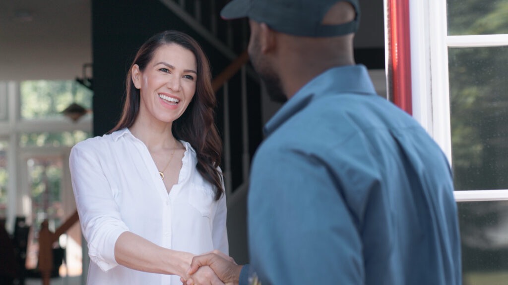 American Pest Technician greeting customer at residential door