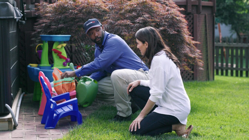 inspecting yard and showing customer breeding grounds for mosquito control