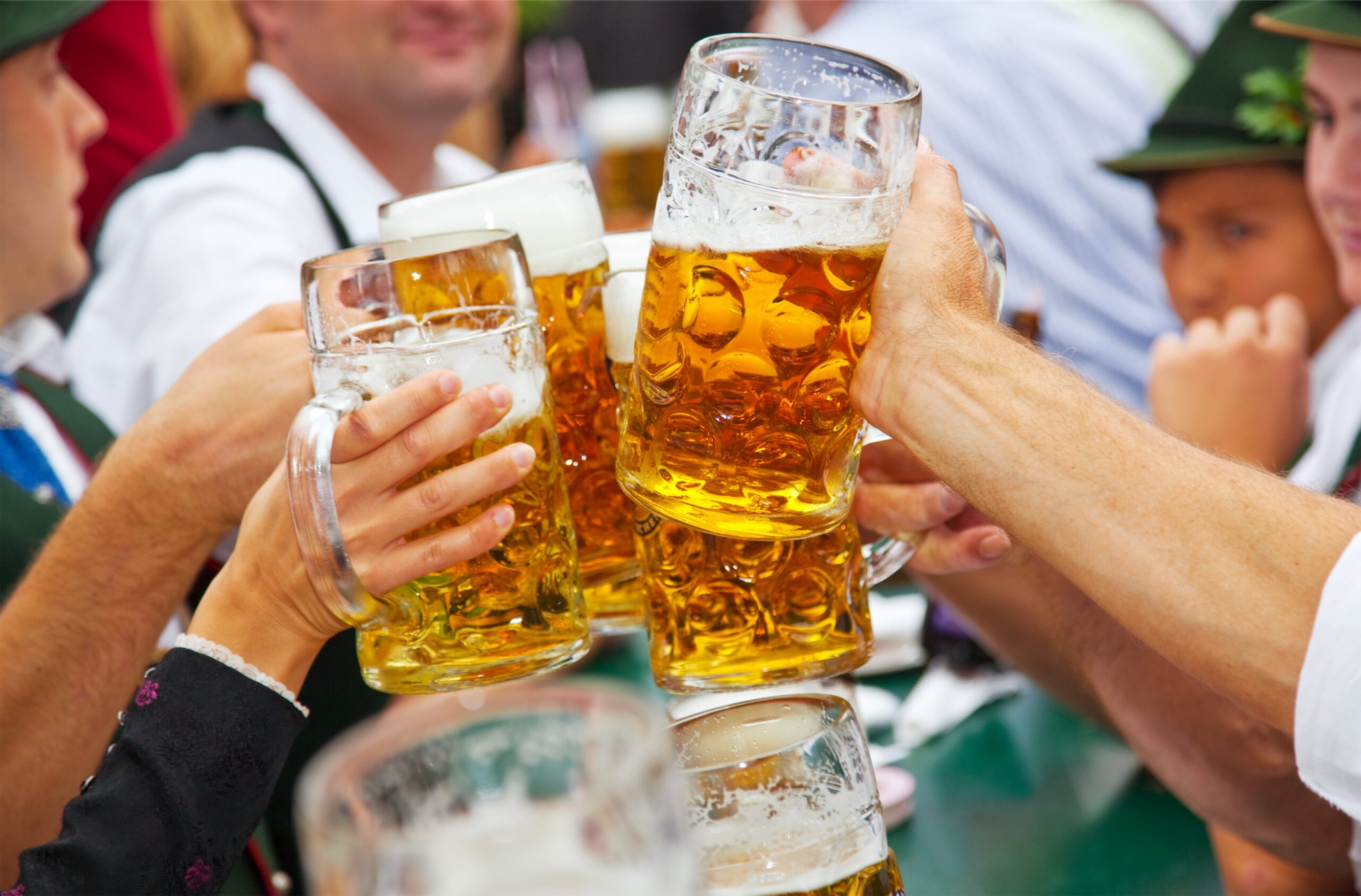 people cheering beer steins at oktoberfest