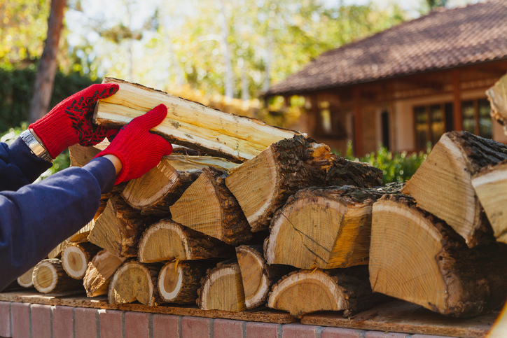 Hands in gloves fold wooden logs