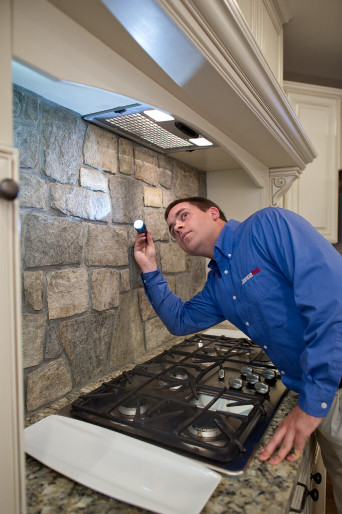 American Pest technician performing kitchen inspection