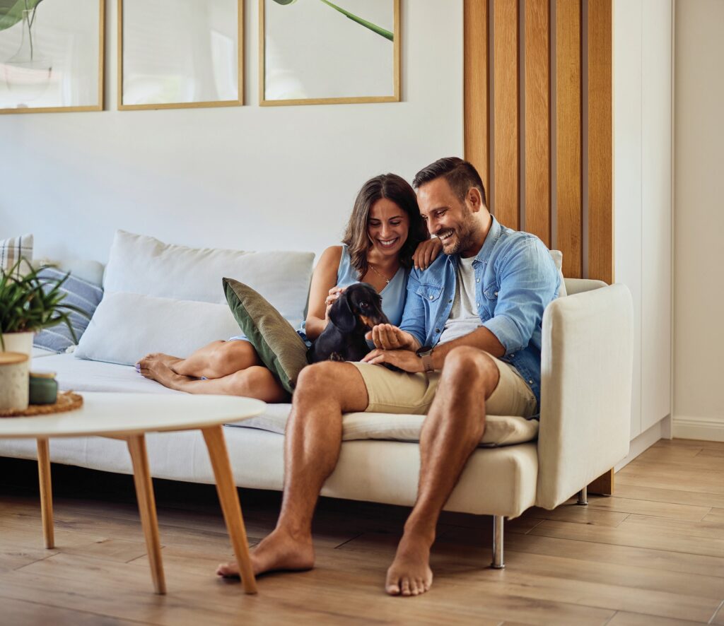 A couple and a dog on a couch